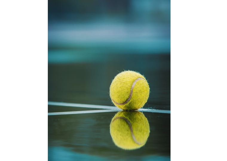 image of a tennis ball reflecting in a puddle