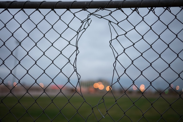 Image of a chain link fence with a hole