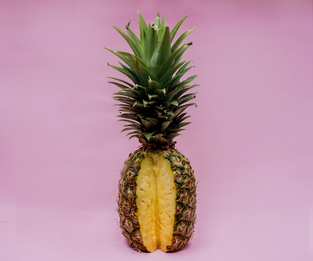 Photo of a pineapple with one wedge sliced out.