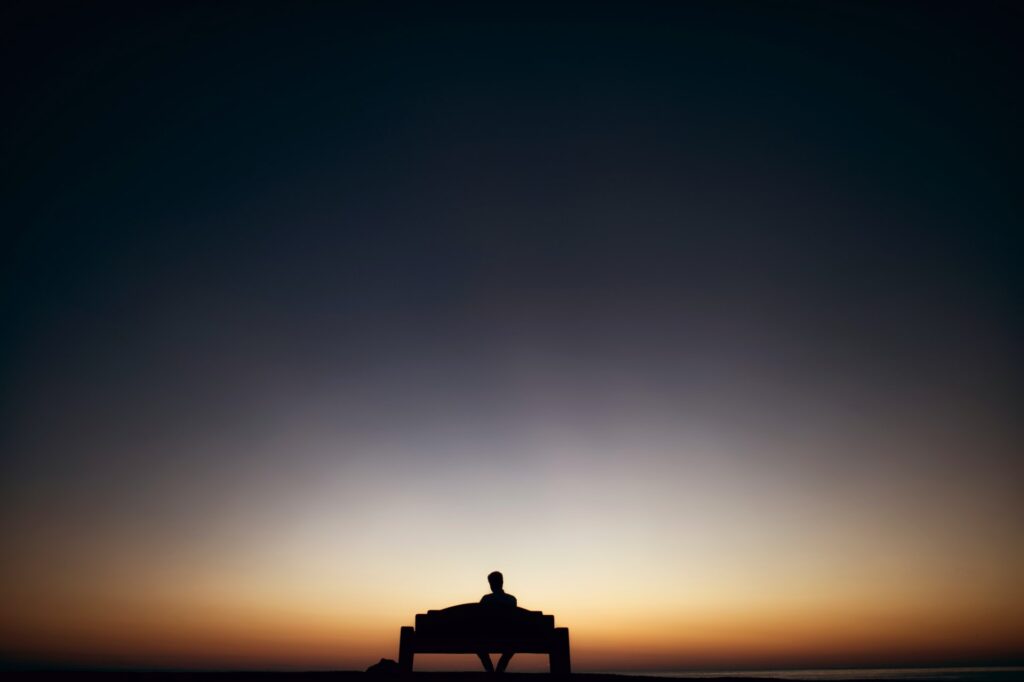 Silouette of a person sitting on a bench