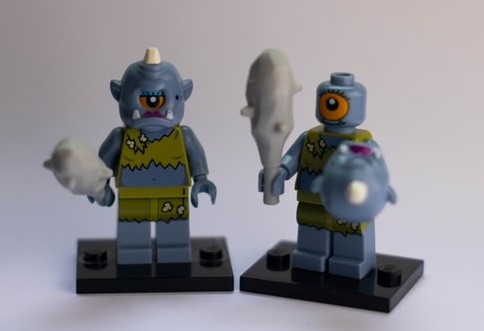 Image of two lLego toys holding bats and shields