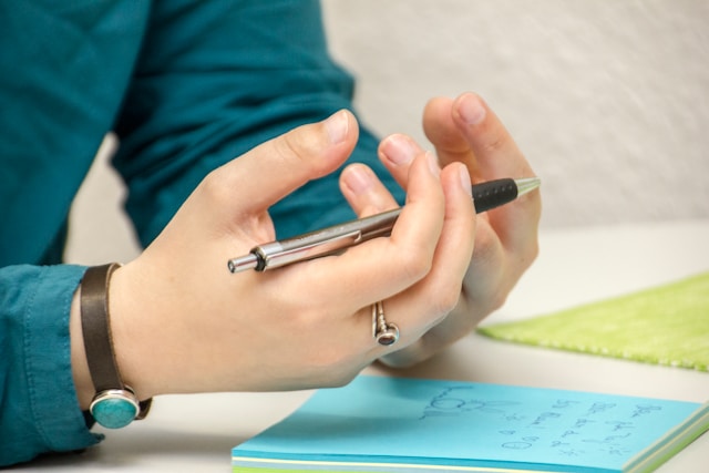 image of two hands holding a pen