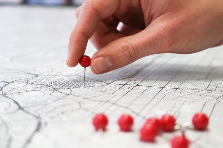 Image of a hand putting pins in a map