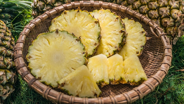 Photo of pineapple slices and wedges in a basket