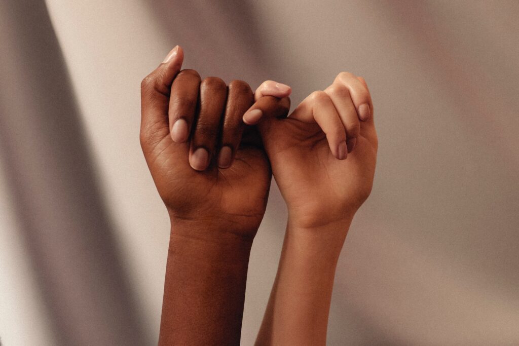 Two hands making a pinky swear.
